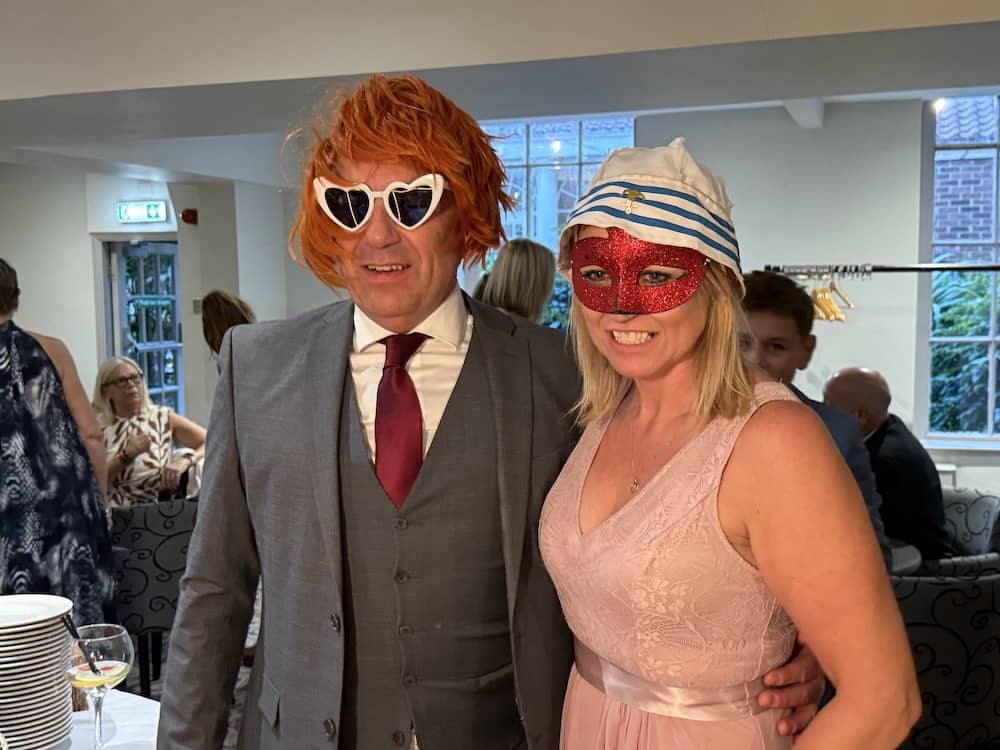 Wedding guests posing with props at the Magic Mirror