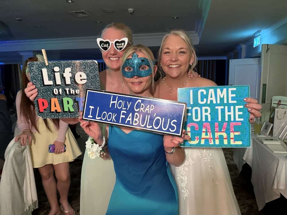 Group of wedding guests posing with props at the Magic Mirror