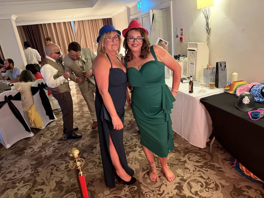 Three wedding guests posing with Magic Mirror hats and glasses