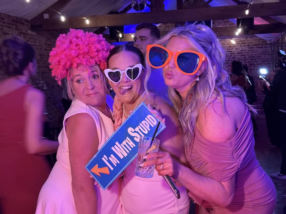 Wedding guests posing with I'm With Stupid sign at the Magic Mirror