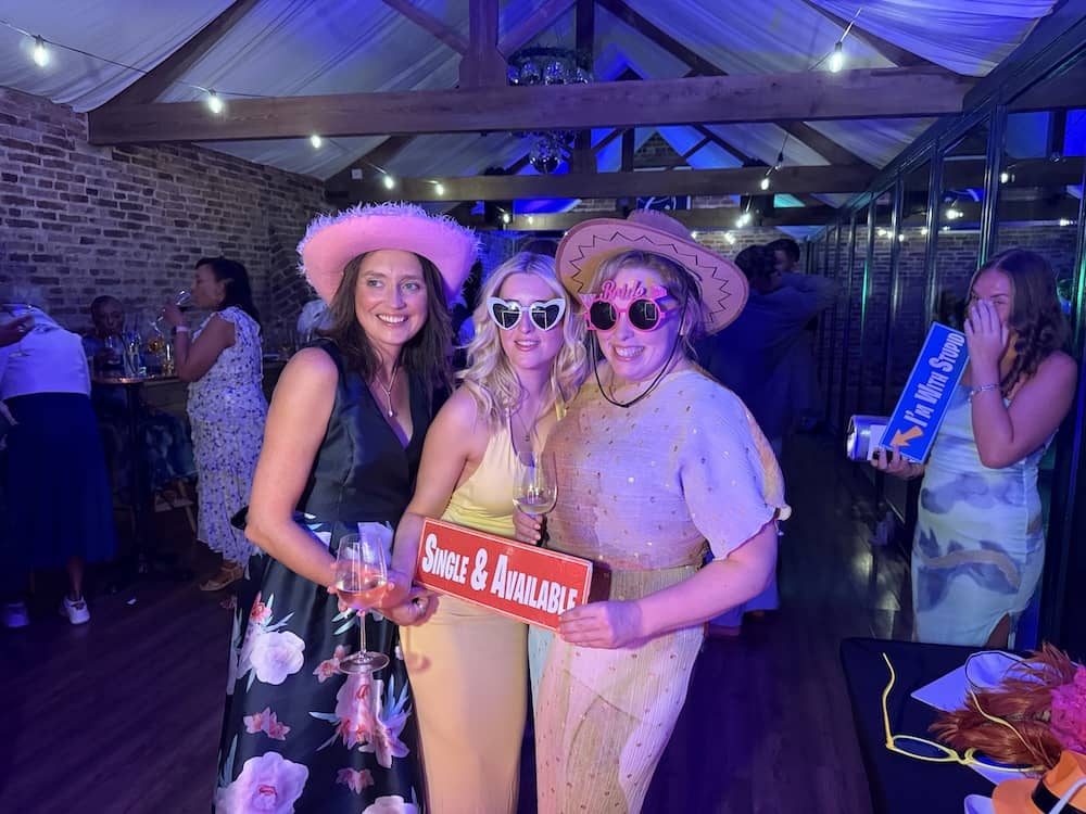 Wedding guests wearing hats and props at the Magic Mirror