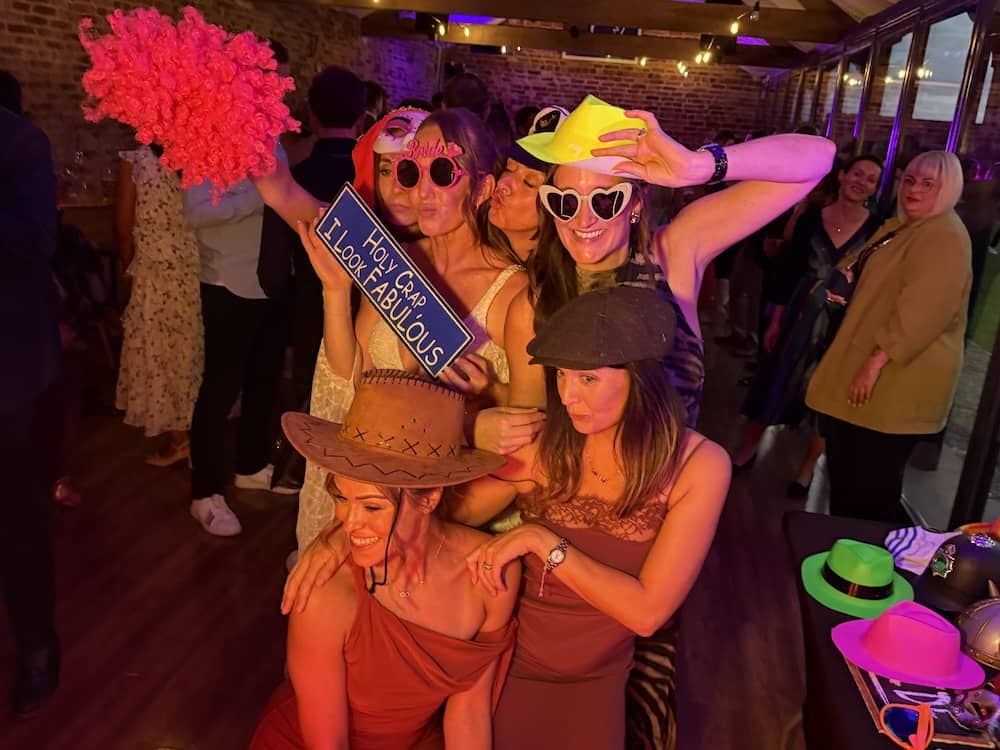 Wedding guests using colourful props at the Magic Mirror at Camblesforth Hall
