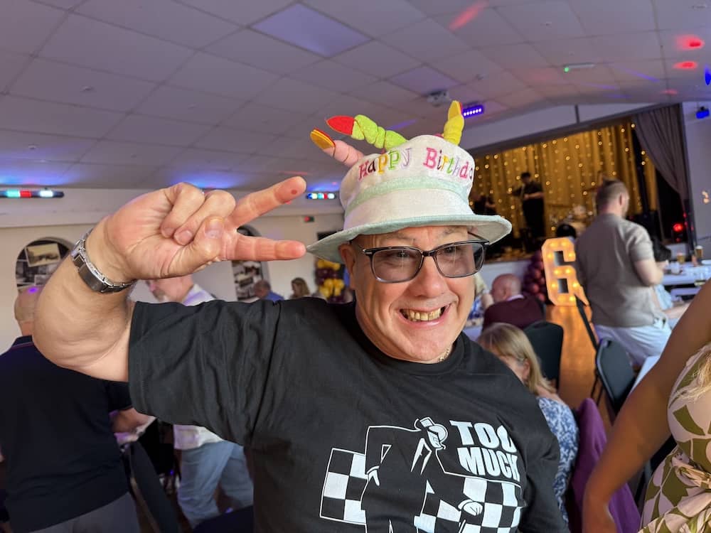 John enjoying his surprise 60th birthday wearing a birthday hat