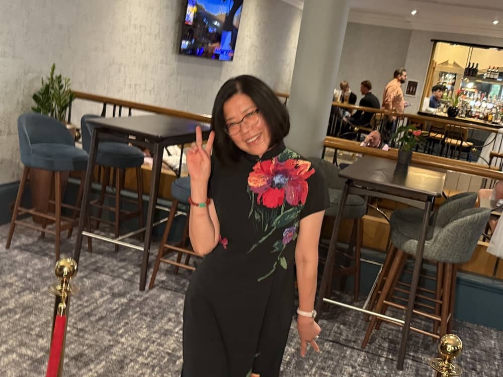 Wedding guest posing with a flower prop at the Magic Mirror