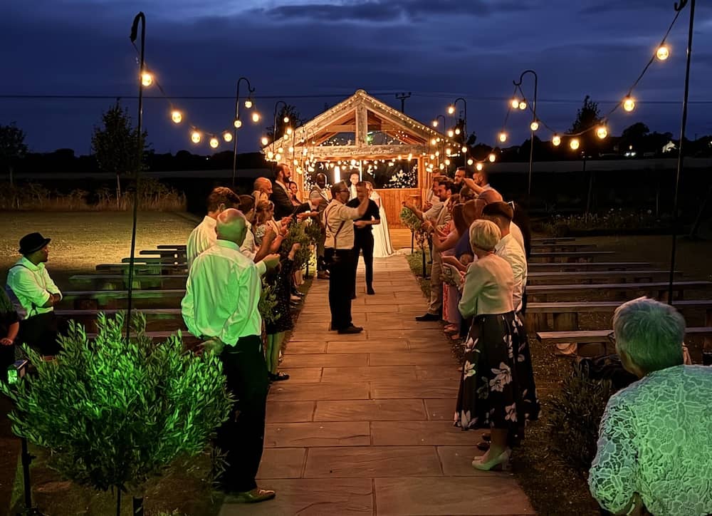 Outdoor evening moment at Beverley Barn with festoon lights